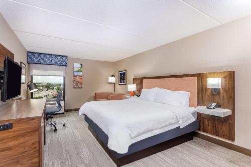 a hotel room with a bed and a flat screen tv at Hampton Inn Harrisburg-East/Hershey in Harrisburg