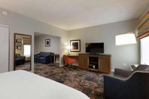 a hotel room with a bed and a flat screen tv at Hampton Inn Houston/Humble-Airport Area in Humble