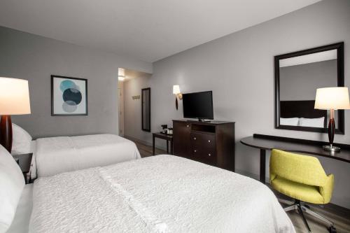 Habitación de hotel con 2 camas, escritorio y TV. en Hampton Inn & Suites Homestead Miami South, en Homestead