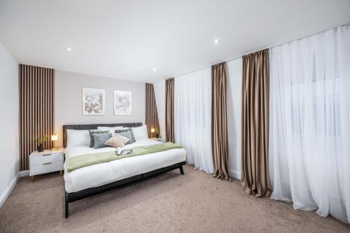 um quarto com uma cama grande e cortinas em Luxury 2 Bedroom Apartment next to Angel em Londres