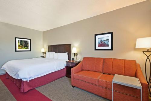 Habitación de hotel con cama y sofá en Hampton Inn Huntington/Barboursville en Barboursville