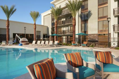 a large swimming pool with chairs and palm trees at Hampton Inn Lake Havasu City in Lake Havasu City