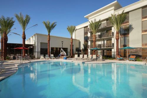 a large swimming pool in front of a building with palm trees at Hampton Inn Lake Havasu City in Lake Havasu City