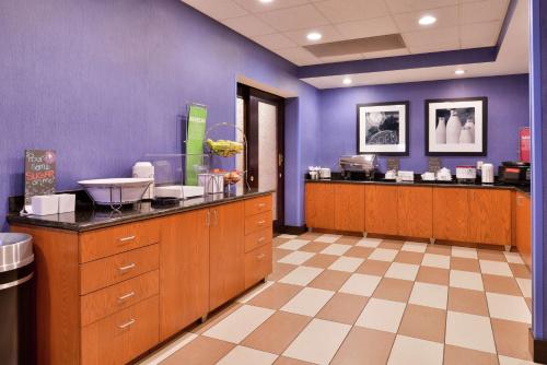 a bathroom with purple walls and a counter with sinks at Hampton Inn Harrisonburg South in Harrisonburg