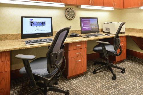 an office cubicle with a desk with a computer and two chairs at Hampton Inn Harrisonburg South in Harrisonburg
