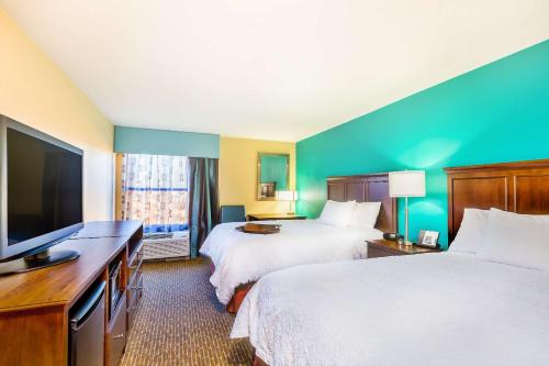 a hotel room with two beds and a flat screen tv at Hampton Inn Huntsville-Arsenal/South Parkway in Huntsville