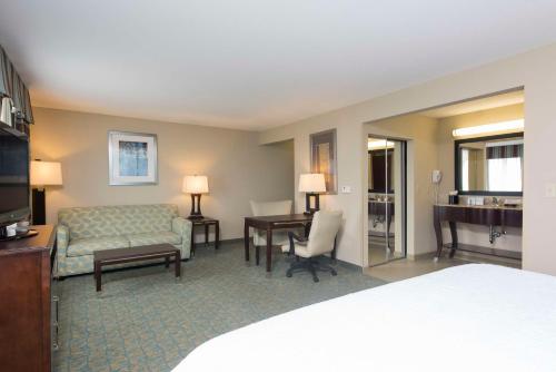 Cette chambre comprend un lit, un canapé et un bureau. dans l'établissement Hampton Inn & Suites Crawfordsville, à Crawfordsville