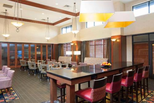 a restaurant with a bar with chairs and tables at Hampton Inn and Suites Indianapolis-Fishers in Fishers