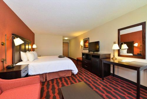 a hotel room with a bed and a television at Hampton Inn Sturgis in Sturgis