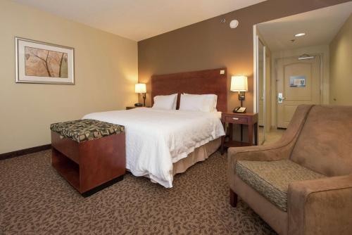 Habitación de hotel con cama y silla en Hampton Inn Yazoo City, en Yazoo City