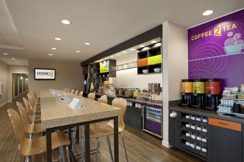 リッジランドにあるHome2 Suites by Hilton Ridgelandの椅子とカウンターのあるバーがあるレストラン