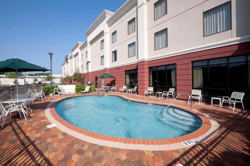 a large swimming pool in front of a building at Hampton Inn Jacksonville I-10 West in Jacksonville