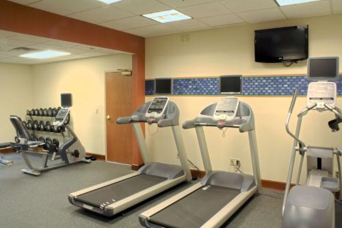 a gym with three tread machines and a flat screen tv at Hampton Inn Jacksonville I-10 West in Jacksonville