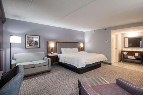 um quarto de hotel com uma cama e um sofá em Hampton Inn Janesville em Janesville