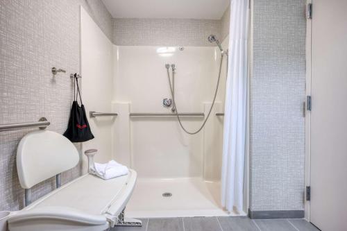 a white bathroom with a shower and a toilet at Hampton Inn Janesville in Janesville