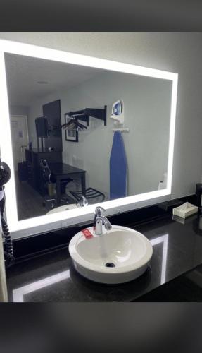 a bathroom with a sink and a large mirror at Rodeway Inn San Antonio Downtown in San Antonio