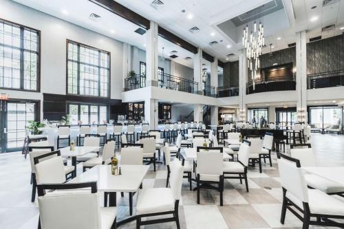Hampton Inn & Suites Fairfield في فيرفيلد: غرفة طعام مع طاولات وكراسي بيضاء