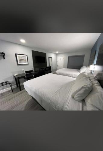 a hotel room with two beds and a desk at Rodeway Inn San Antonio Downtown in San Antonio