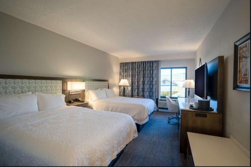 a hotel room with two beds and a television at Hampton Inn & Suites Fairfield in Fairfield