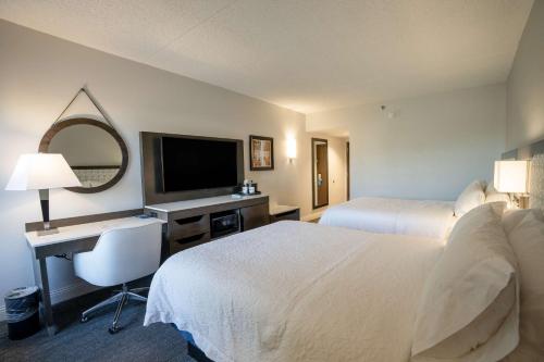 a hotel room with two beds and a desk with a television at Hampton Inn & Suites Fairfield in Fairfield