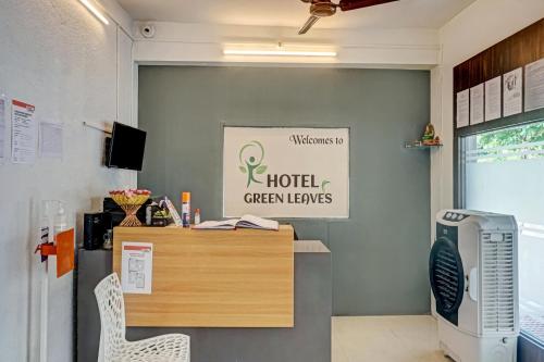 Hotel Green Leaves في Māngvādi: مكتب به مكتب وحواسيب لابتوب خضراء تابعة للفندق