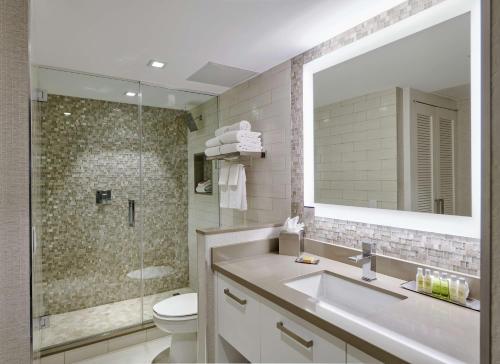 a bathroom with a sink and a toilet and a mirror at Bahia Mar Fort Lauderdale Beach - DoubleTree by Hilton in Fort Lauderdale
