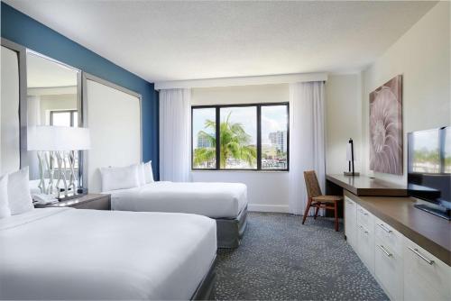 a hotel room with two beds and a television at Bahia Mar Fort Lauderdale Beach - DoubleTree by Hilton in Fort Lauderdale