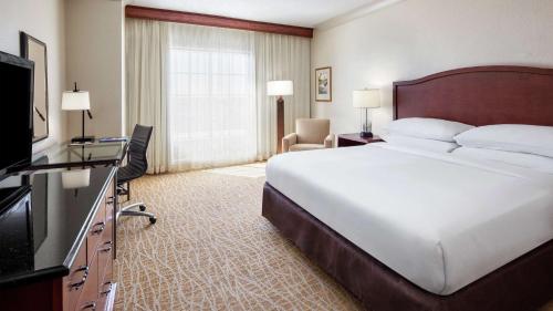 a hotel room with a large bed and a television at DoubleTree by Hilton Sunrise - Sawgrass Mills in Sunrise