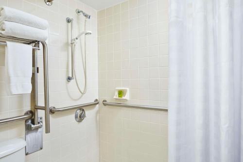 La salle de bains est pourvue d'une douche avec rideau de douche. dans l'établissement Embassy Suites by Hilton Fort Lauderdale 17th Street, à Fort Lauderdale