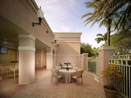 a patio with a table and chairs on a balcony at DoubleTree by Hilton Sunrise - Sawgrass Mills in Sunrise