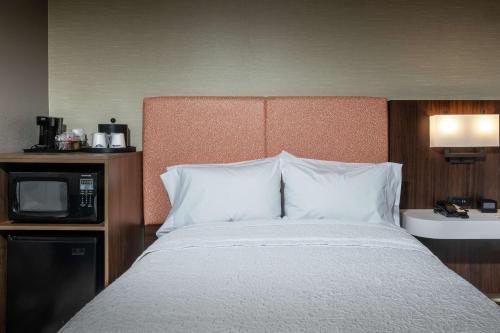 a bed in a hotel room with a microwave at Hampton Inn Fall River/Westport in North Westport
