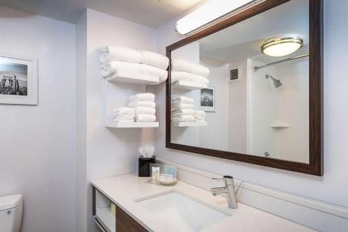 W białej łazience znajduje się umywalka i lustro. w obiekcie Hampton Inn Fall River/Westport w mieście North Westport