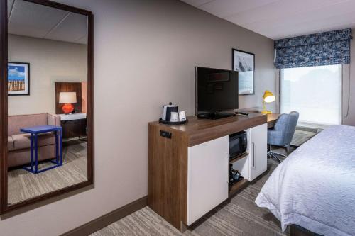 a hotel room with a bed and a mirror at Hampton Inn Fall River/Westport in North Westport