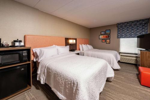 a hotel room with two beds and a television at Hampton Inn Fall River/Westport in North Westport