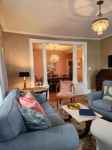 a living room with a blue couch and a table at Stone Carriage House in Picton