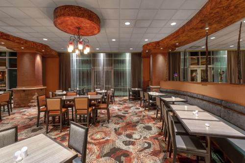 a restaurant with tables and chairs in a room at Embassy Suites Loveland Conference Center in Loveland