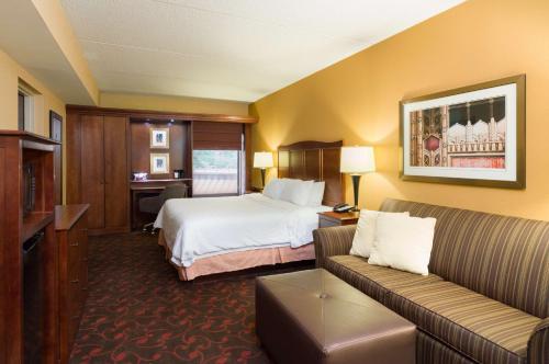 a hotel room with a bed and a couch at Hampton Inn Carlisle in Carlisle