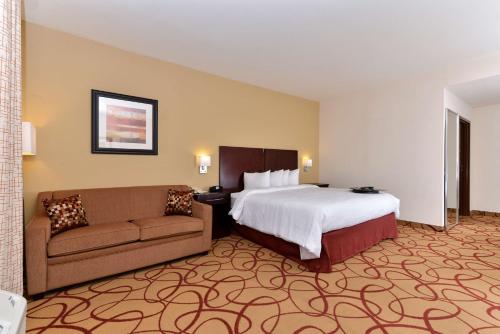 Habitación de hotel con cama y sofá en Hampton Inn Houston-Deer Park Ship Area, en Deer Park