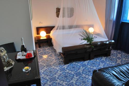 a living room with a bed and a couch at B&B Il Resort Dell'Artista in Venetico