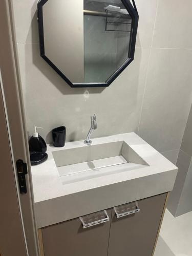 y baño con lavabo blanco y espejo. en Flat FM20 - apt.402. Cabo Branco, en João Pessoa