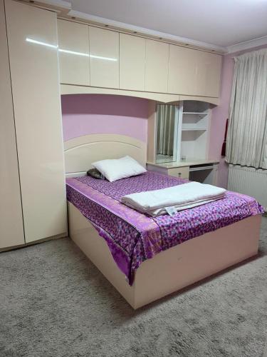 a bedroom with a large bed with a purple and white bedspread at Krystal Residence in London