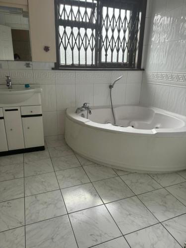 a white bath tub in a bathroom with a sink at Krystal Residence in London