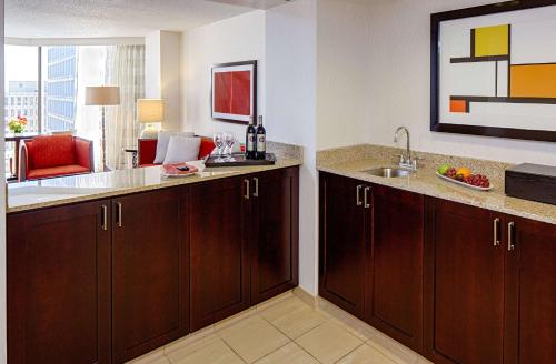a kitchen with wooden cabinets and a sink in a room at DoubleTree by Hilton Hotel Houston Greenway Plaza in Houston