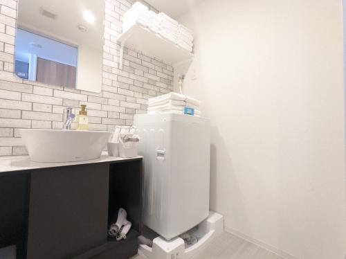 a bathroom with a white toilet and a sink at ESLEAD HOTEL Namba South Ⅲ in Osaka