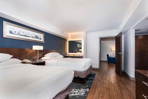 a hotel room with two beds and a television at Embassy Suites by Hilton Indianapolis Downtown in Indianapolis