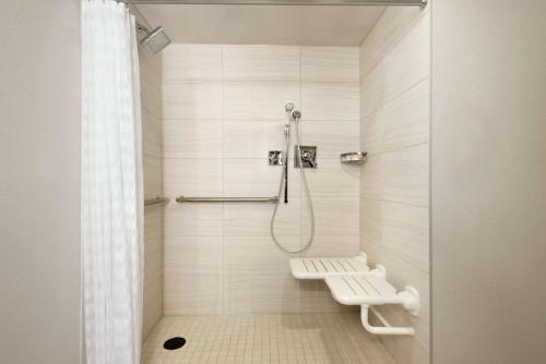 a bathroom with a shower with a bench in it at Embassy Suites by Hilton Indianapolis Downtown in Indianapolis