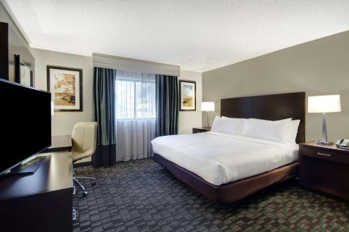 a hotel room with a bed and a flat screen tv at Embassy Suites by Hilton Jacksonville Baymeadows in Jacksonville