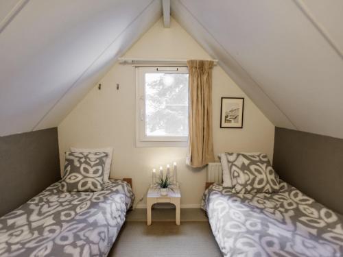 Daumazan-sur-ArizeにあるVilla Campagne 85の屋根裏のベッドルーム(ベッド2台、窓付)