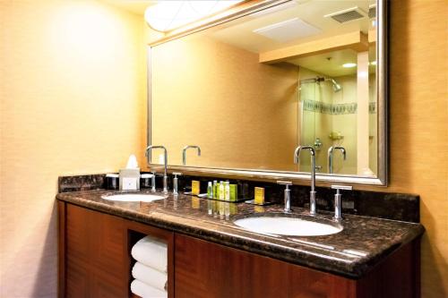 a bathroom with two sinks and a large mirror at DoubleTree by Hilton San Jose in San Jose