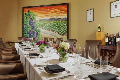 a long table in a restaurant with a painting at DoubleTree by Hilton San Jose in San Jose